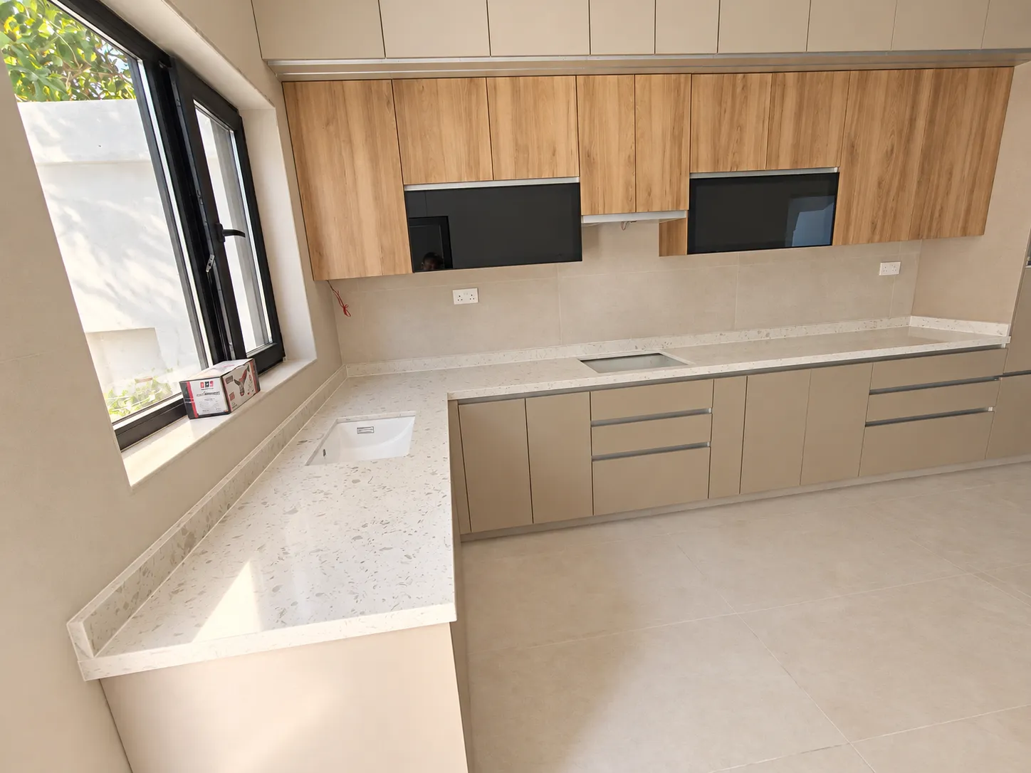 مطبخ خشبي وبيج يظهر من خلف سطح العمل